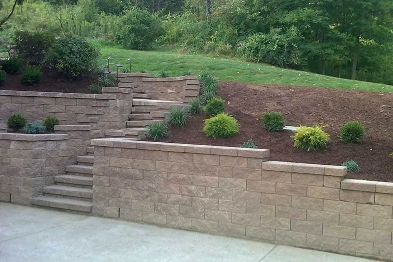 photo of segmented driveway retaining wall and stairs installed by Wichman Landscape Construction
